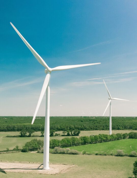 Two wind turbines in fields